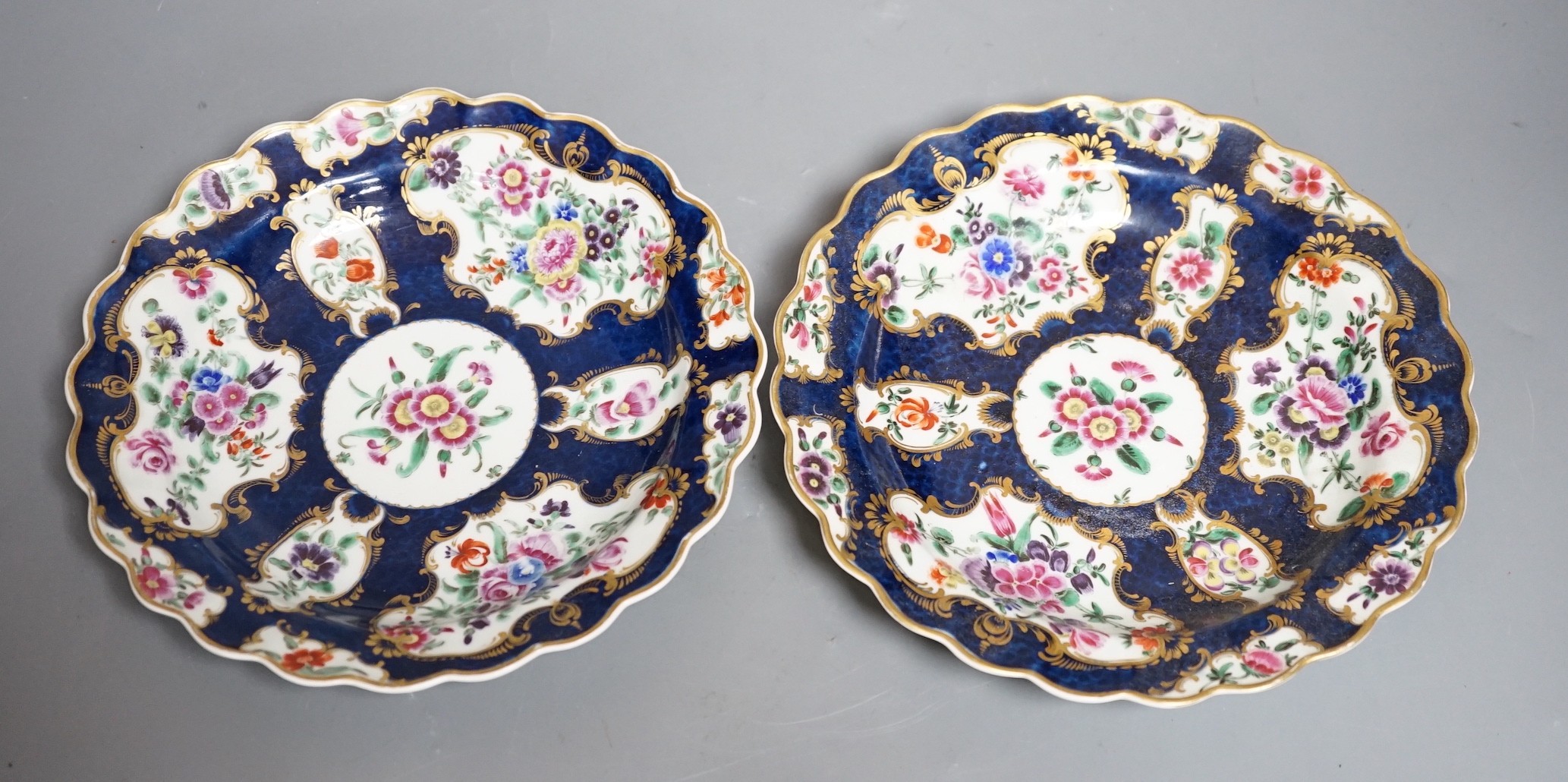 A fine pair of Worcester blue scale plates gilded with mirror like panels, painted with flowers, with fretted square mark, 19cms diameter